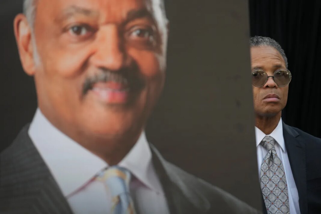 Jesse Jackson, Jr. stands near a picture of his father, the late Rev. Jesse Jackson, during a news conference outside the family home in Chicago, Wednesday, Feb. 18, 2026. (AP Photo/Erin Hooley)