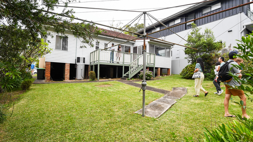 A hills hoist clothesline in a back yard.