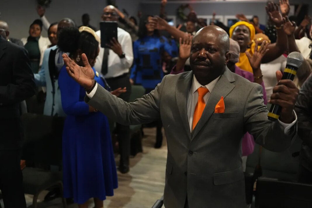 Rev. Reginald Silencieux, right, leads a worship service at the First Haitian Evangelical Church of Springfield, Sunday, Feb. 1, 2026, in Springfield, Ohio. (AP Photo/Luis Andres Henao)