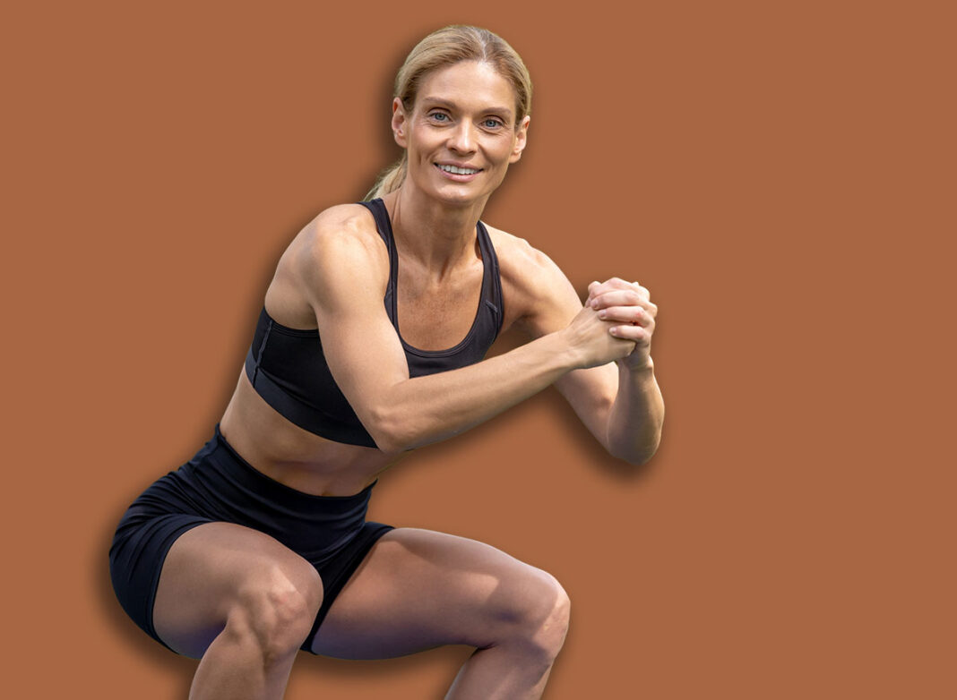 Beautiful woman working out doing squats in summer park.