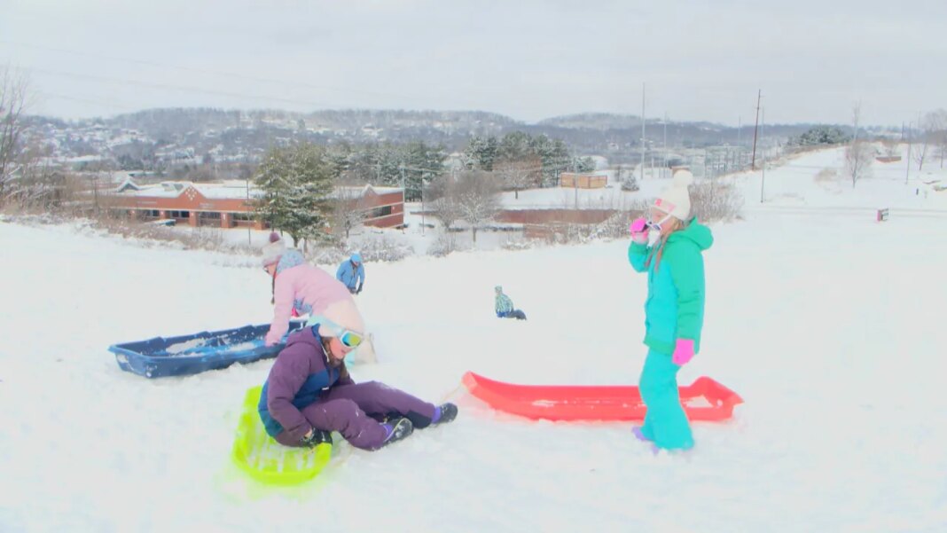 Johnson City families enjoy snow by sledding