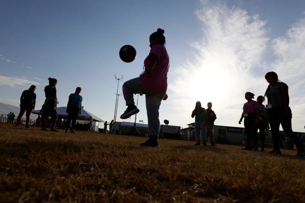 FILE - Immigrants play soccer at a new U.S. government holding center for migrant children, in Carrizo Springs, Texas, July 9, 2019. (AP Photo/Eric Gay, File)