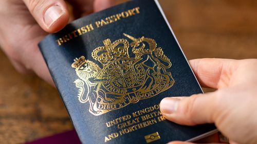 man recieving new post Brexit blue British passport with old European Union red one the table Devon, United Kingdom, January, 2021.