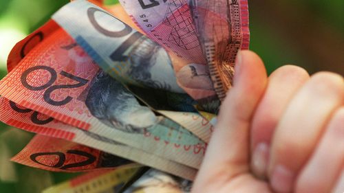 Someone holding a handful of Australian cash.
