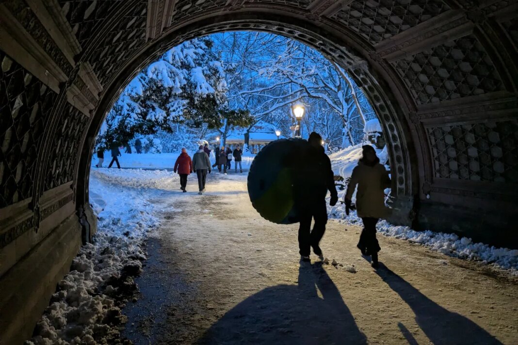 A man carries an inflatable inner-tube for snow sledding in Prospect Park in the borough of Brooklyn, New York, on Monday, Feb. 23, 2026. (AP Photo/Drew Callister)