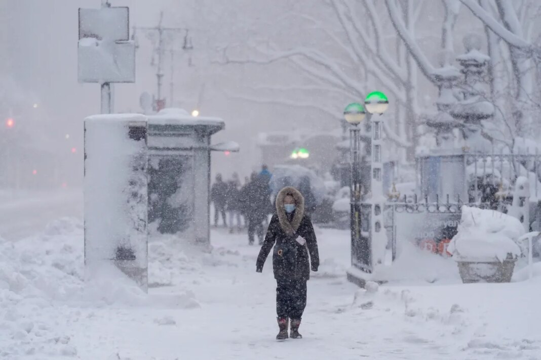 A pedestrian walks along 42nd Street near Bryant Park during a snow storm, Monday, Feb. 23, 2026, in New York. (AP Photo/Seth Wenig)