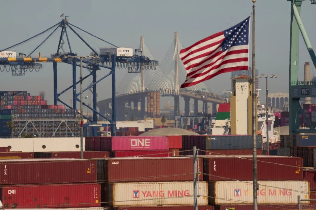 FILE - Containers with Yang Ming Marine Transport Corporation, a Taiwanese container shipping company, are stacked up at the Port of Los Angeles with the the Long Beach International Gateway Bridge seen in the background on Wednesday, April 9, 2025 in Los Angeles. (AP Photo/Damian Dovarganes, File)