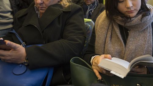 At the end of a work day, commuters ride a metro train traveling from Flinders Street Station to points outside the city center of Melbourne, Australia