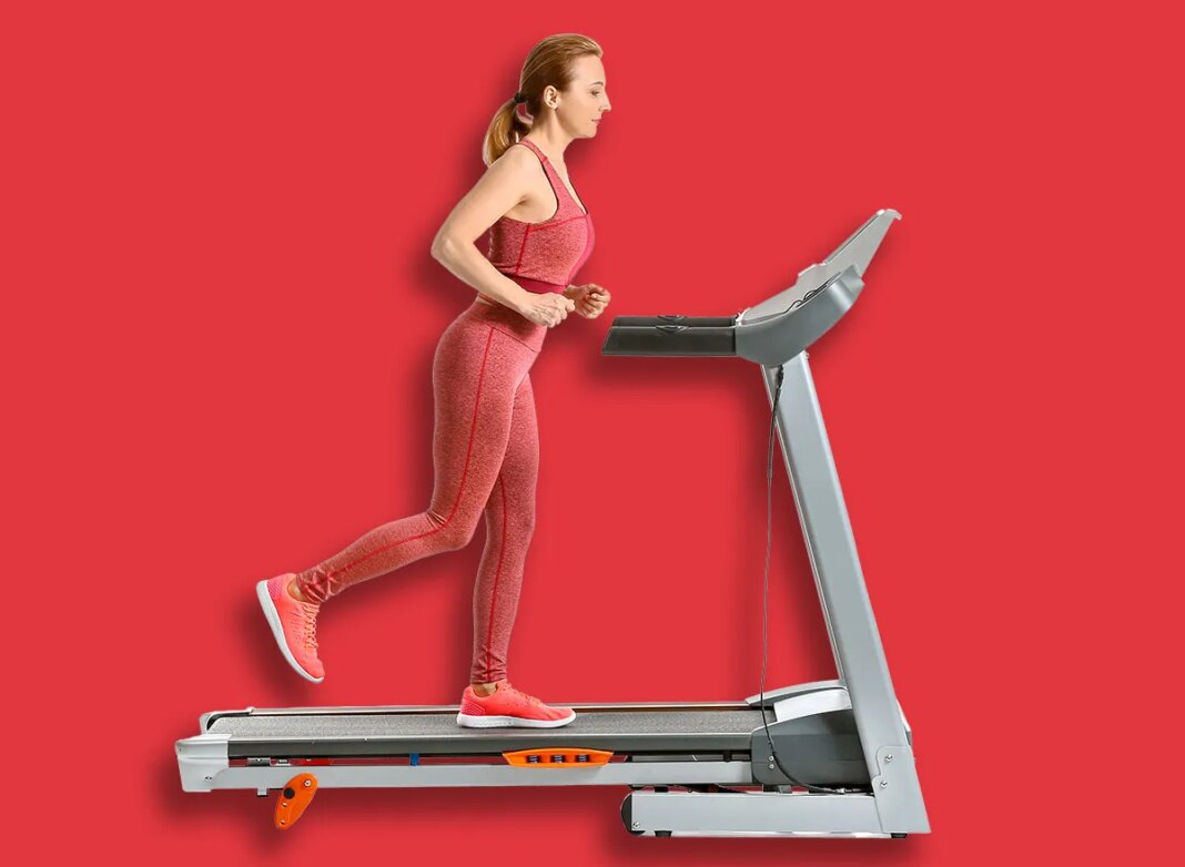 Sporty woman training on treadmill against white background