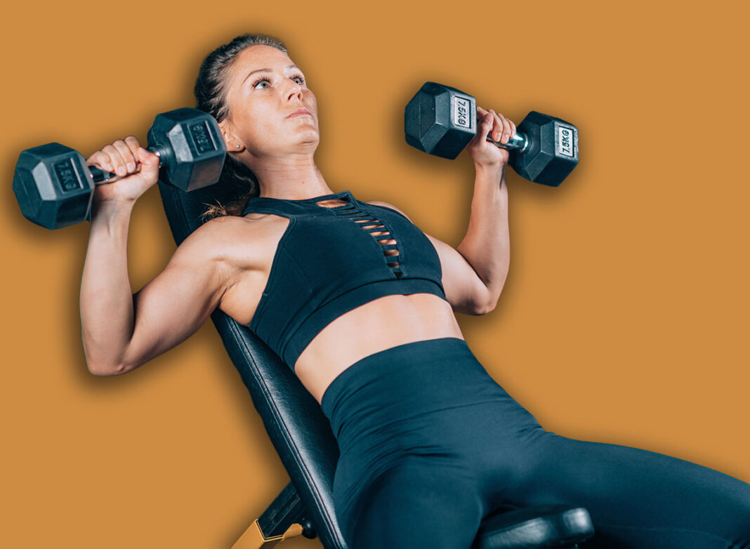 Female Athlete Exercising with Dumbbells in the Gym. Strength Training.