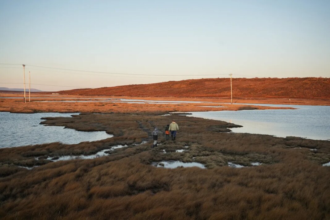 FILE - Roswell Schaeffer, an Inupiaq hunter and fisher, takes his great-grandson James Schaeffer, 7, and James