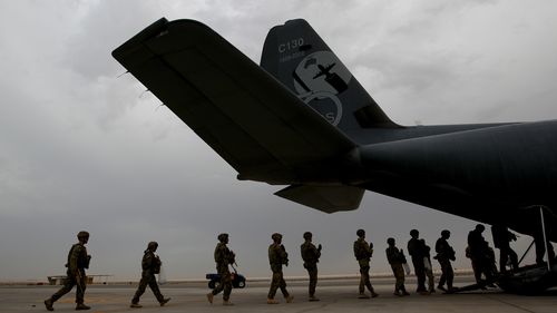 Australian troops board a C-130 aircraft departing Al Minhad Air Base in 2013.