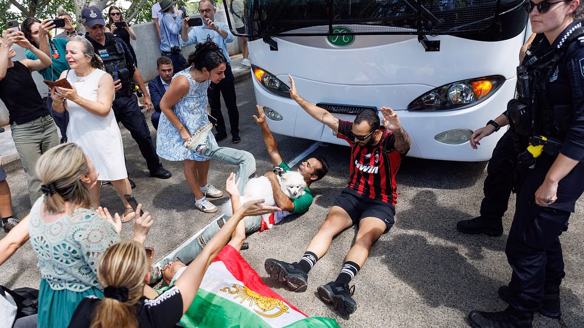 Chaos as protesters try to stop Iranian soccer stars from flying home early from Australia - as one star is DRAGGED onto bus