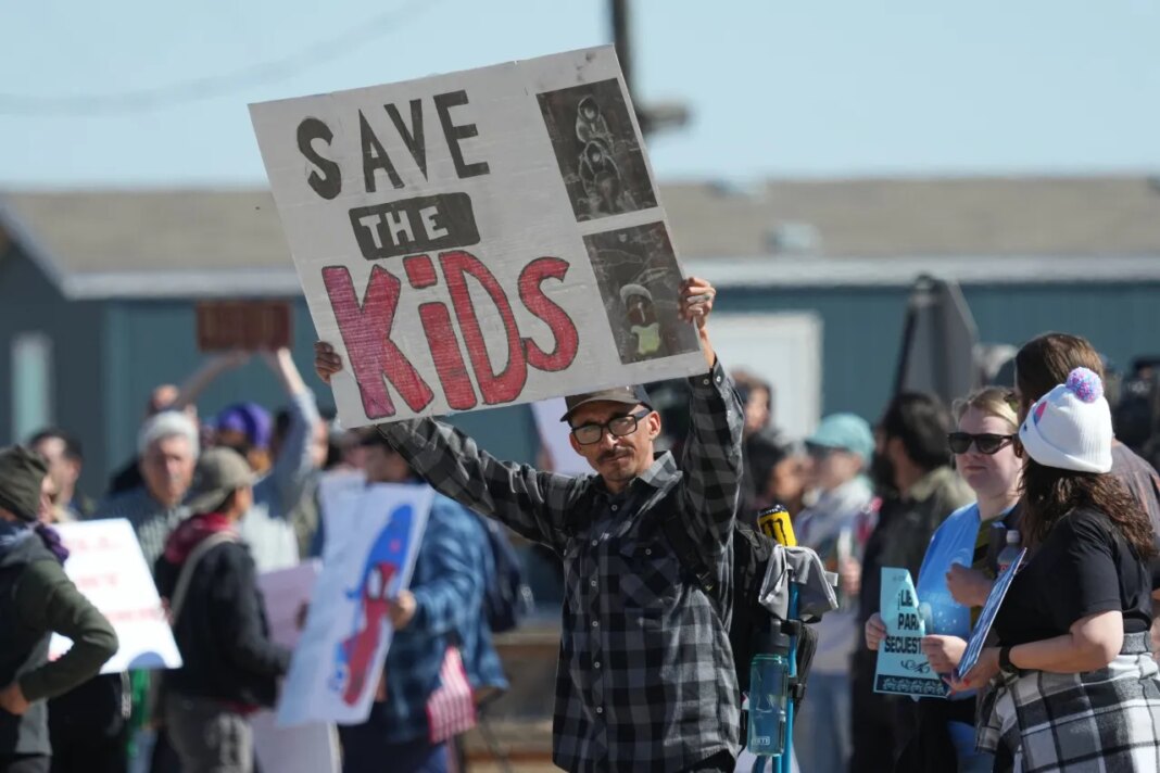 FILE - Protesters gather outside the South Texas Family Residential Center detention facility where Liam Ramos and his father are being detained in Dilley, Texas, Wednesday, Jan. 28, 2026. (AP Photo/Eric Gay, File)