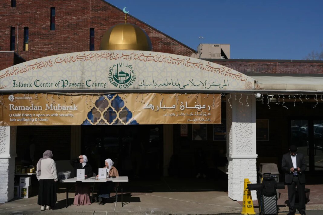 Leen Shella, center, and Haneen Alatiyat, right, prepare to encourage congregants to vote in the New Jersey primary elections during Ramadan outside the Islamic Center of Passaic County on Friday, Feb. 27, 2026. (AP Photo/Luis Andres Henao)