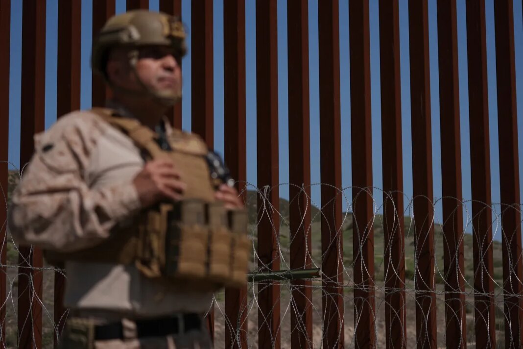 FILE - A Marine stands front of newly-installed concertina wire lining one of two border walls separating Mexico from the United States during a news conference, March 21, 2025, in San Diego. (AP Photo/Gregory Bull, File)