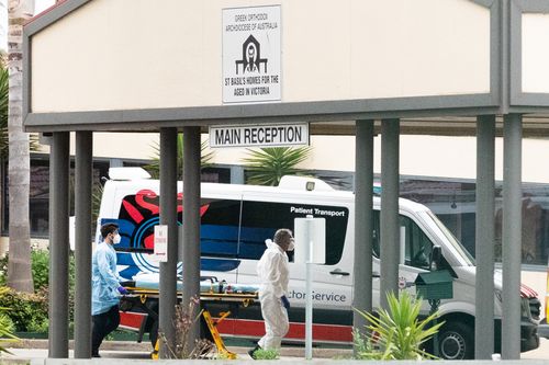 MELBOURNE, AUSTRALIA - JULY 27: Ambulance service workers push a stretcher into the St Basil's homes for the Aged facility in Fawkner on July 27, 2020 in Melbourne, Australia. Victoria has recorded 532 new cases of coronavirus and six more deaths. Metropolitan Melbourne and the Mitchell shire remain in lockdown due to the rise in COVID-19 cases through community transmissions, with people permitted to leave home only for exercise, work, to buy essential items, or to access childcare and healthca