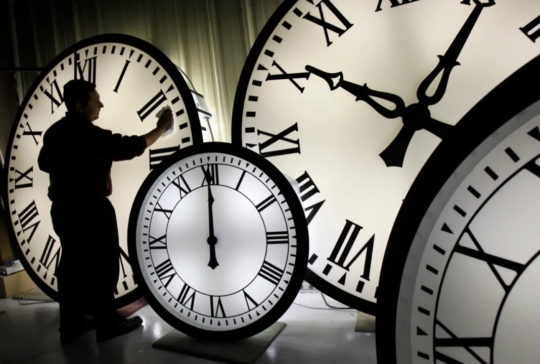 FILE - Electric Time Co. employee Walter Rodriguez cleans the face of an 84-inch Wegman clock at the plant in Medfield, Mass. Thursday, Oct. 30, 2008. (AP Photo/Elise Amendola, File)
