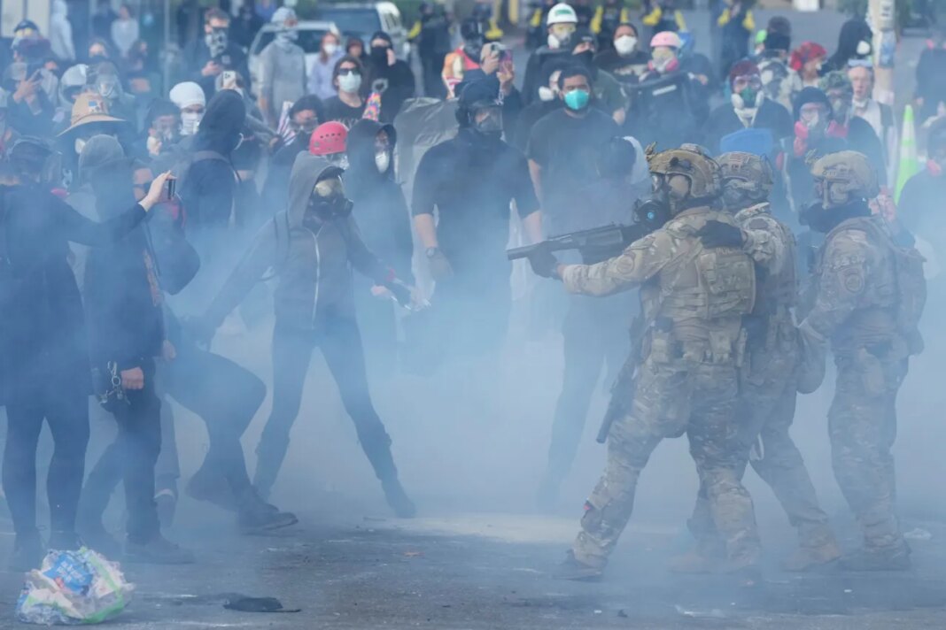 FILE - U.S. Customs and Border Protection agents standoff against demonstrators as tear gas fills the air outside the U.S. Immigration and Customs building during a protest in Portland, Ore., June 14, 2025. (AP Photo/Jenny Kane, File)