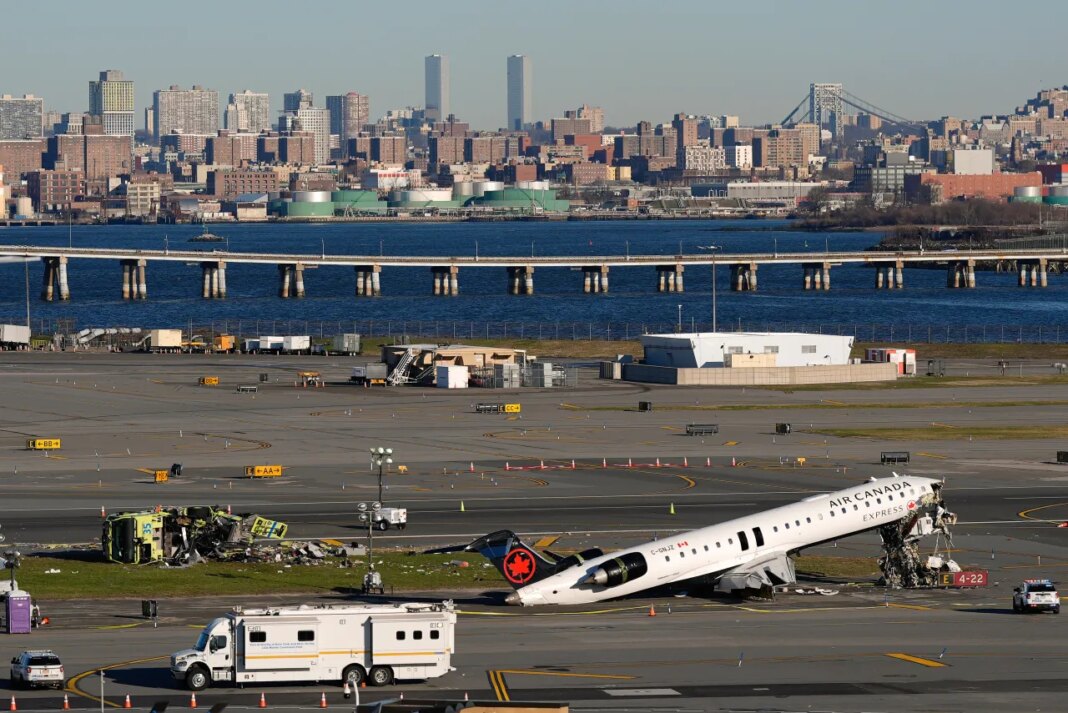 An Air Canada Express jet and Port Authority fire truck lay on the side of a runway at LaGuardia Airport, Tuesday, March 24, 2026, after colliding with each other shortly after the jet landed in New York Sunday night. (AP Photo/Yuki Iwamura)
