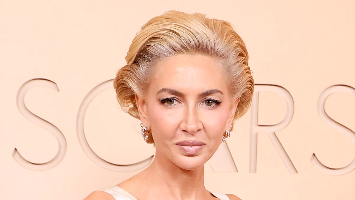Socialite Sabine Getty's gown gets STUCK in escalator at the Oscars