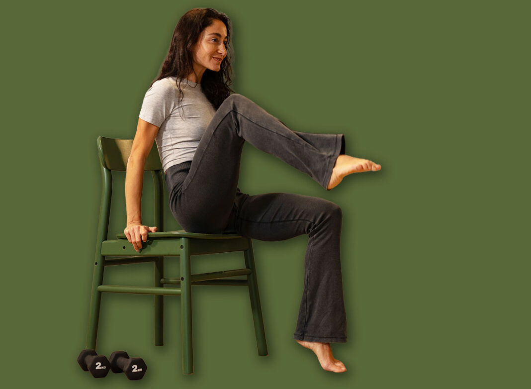 Athletic woman performing seated core exercise on chair at home