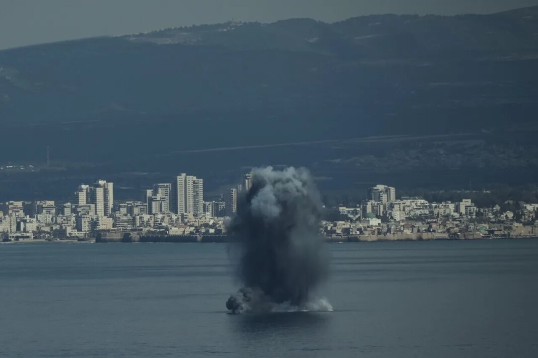 An incoming projectile explodes over the water as Israel issues a nationwide alert following its strikes on Iran, in Haifa Bay, northern Israel, Saturday, Feb. 28, 2026. (AP Photo/Leo Correa)
