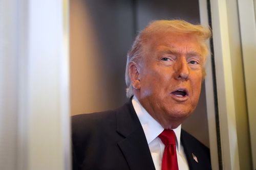 President Donald Trump speaks to reporters while traveling aboard Air Force One