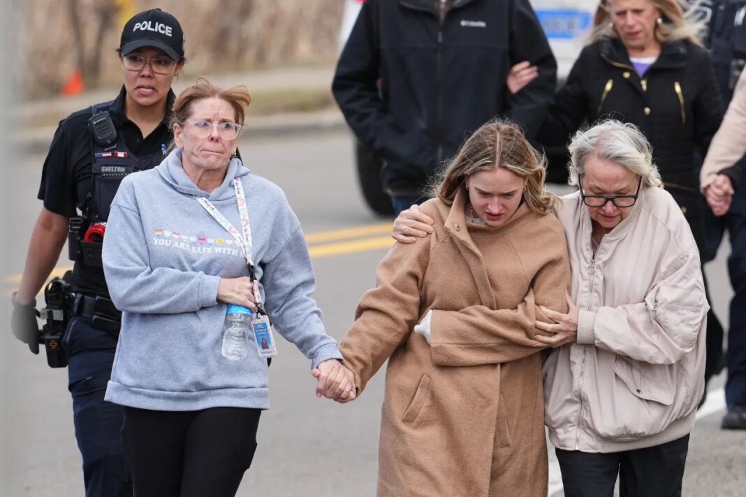 Law enforcement escort families away from the Temple Israel synagogue Thursday, March 12, 2026, in West Bloomfield Township, Mich. (AP Photo/Paul Sancya)
