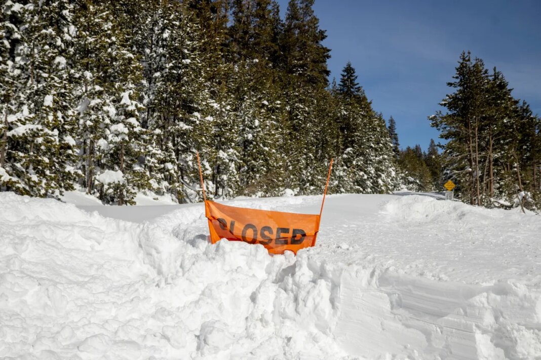 FILE - A closed sign is partially buried at the entrance to the Castle Peak trailhead in Soda Springs, Calif., Friday, Feb. 20, 2026. (Stephen Lam/San Francisco Chronicle via AP, File)