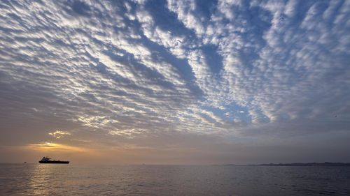 The sun rises behind a tanker anchored in the Strait of Hormuz off the coast of Qeshm Island, Iran.