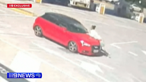 Car swerves along road, trying to shake off woman clinging onto bonnet