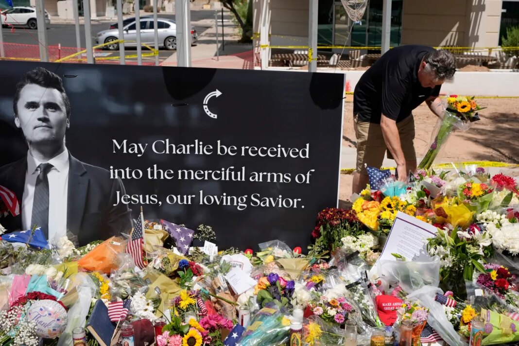 FILE - A well-wisher places flowers at a makeshift memorial set up for Charlie Kirk at Turning Point USA headquarters, Sept. 11, 2025, in Phoenix. (AP Photo/Ross D. Franklin, File)