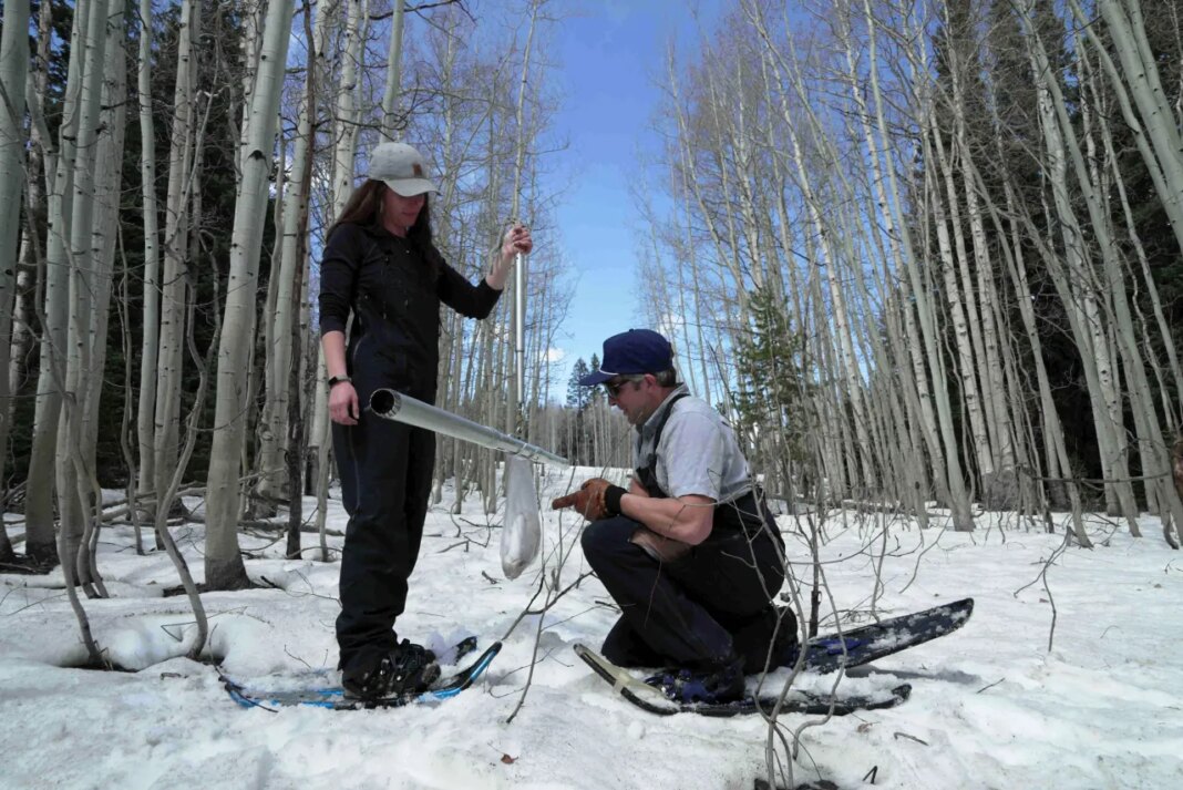 Snow surveyors, hydrologist, Maureen Gutsch, left, and Clinton Whitten weigh a snow sample, Monday, March 30, 2026, in Kremmling, Colo. (AP Photo/Brittany Peterson)
