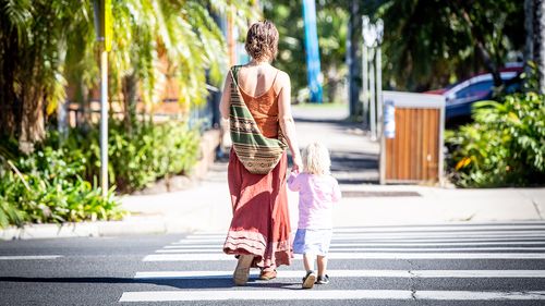 Generic image of a mother and child crossing the road.