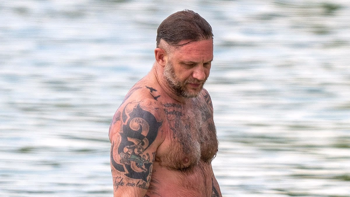 Shirtless Tom Hardy displays his vast collection of tattoos