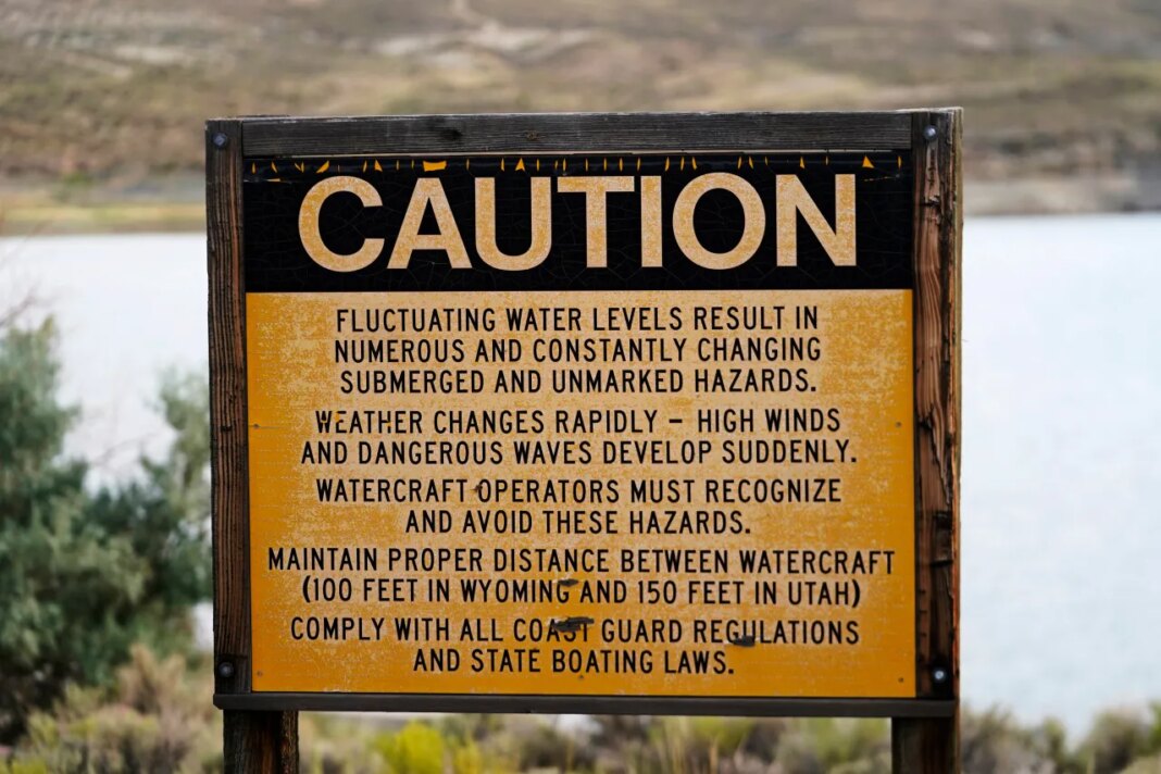 FILE - A sign cautioning fluctuating water levels is displayed at Firehole Canyon, on the far northeastern shore of Flaming Gorge Reservoir, Friday, Aug. 5, 2022, in Wyoming. (AP Photo/Rick Bowmer, File)