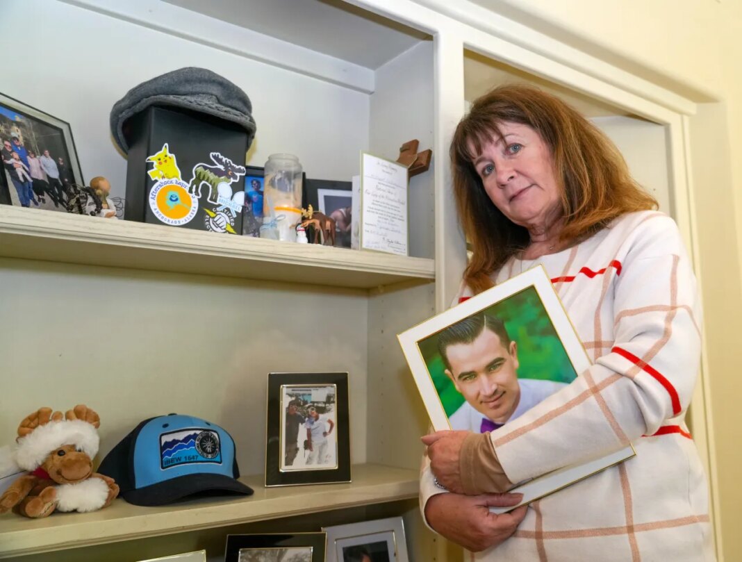 Kelley Nalewaja stands by a memorial for her son, Michael Nalewaja, seen in the photo, who died after unknowingly taking a lethal cocktail of fentanyl and carfentanil in November 2025, at her home in El Dorado Hills, Calif., Thursday, April 16, 2026. (AP Photo/Rich Pedroncelli)