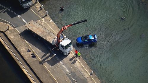 Car being pulled from the water. 