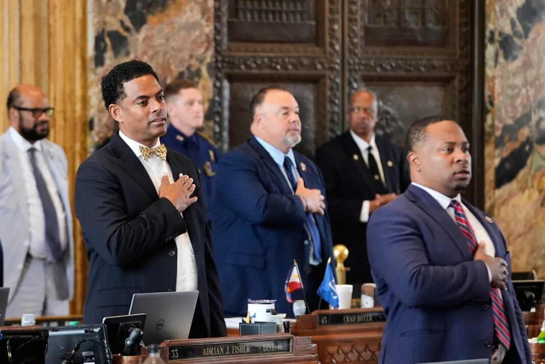 Louisiana Reps. Adrian Fisher, D-Dist 16, left, Chad Michael Boyer, R-Dist 46, and C. Travis Johnson, D-Dist 21, right, recite the pledge of allegiance prior to a house vote on a redistricting plan to eliminate a majority-Black congressional district in response to a U.S. Supreme Court ruling, in Baton Rouge, La., Thursday, May 21, 2026. (AP Photo/Gerald Herbert)