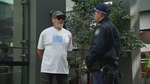 A man has been given move-on orders by police after wearing a shirt bearing a swastika outside the building in which the royal commission is being held. 