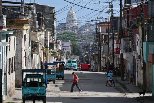 A man crosses a street in Havana, Cuba.