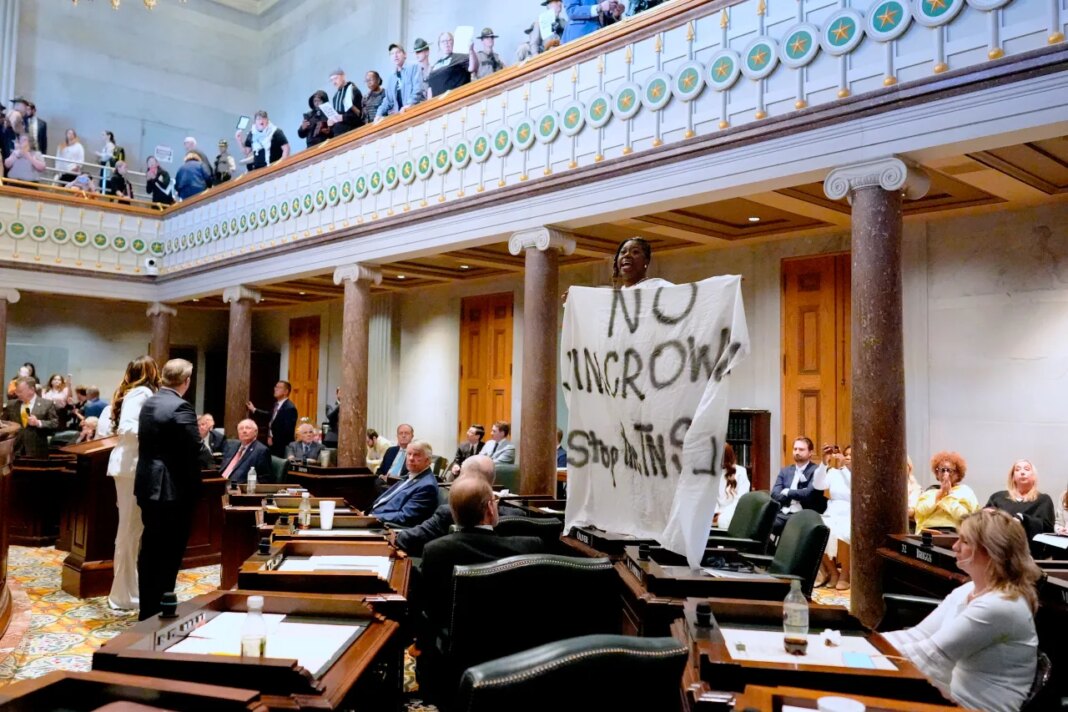 Sen. Charlane Oliver, D-Nashville, holds a banner and protests atop her desk on the Senate floor during a special session of the state legislature to redraw U.S. Congressional voting maps Thursday, May 7, 2026, in Nashville, Tenn. (AP Photo/George Walker IV)