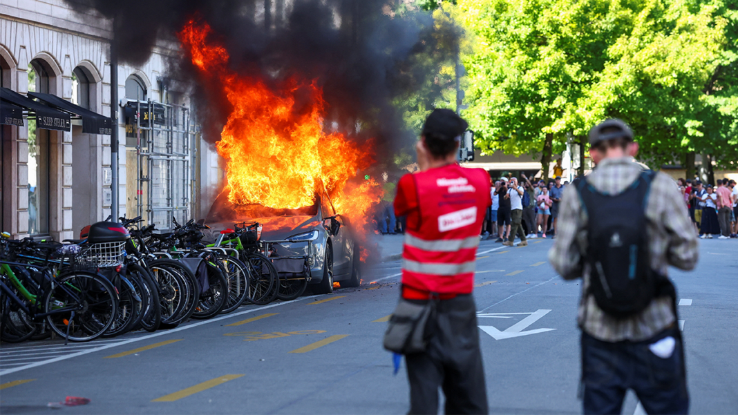 Anti-G7 protest turns violent as demonstrators torch Tesla and smash UN office windows