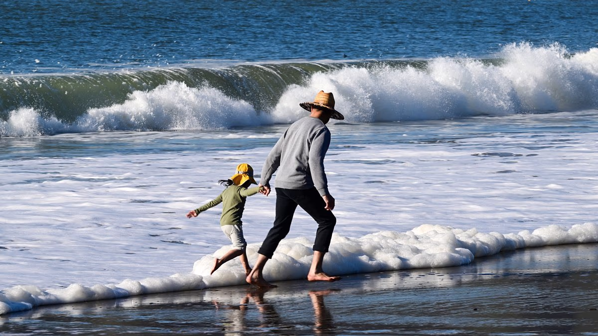Mother and child in critical condition after being swept into sea