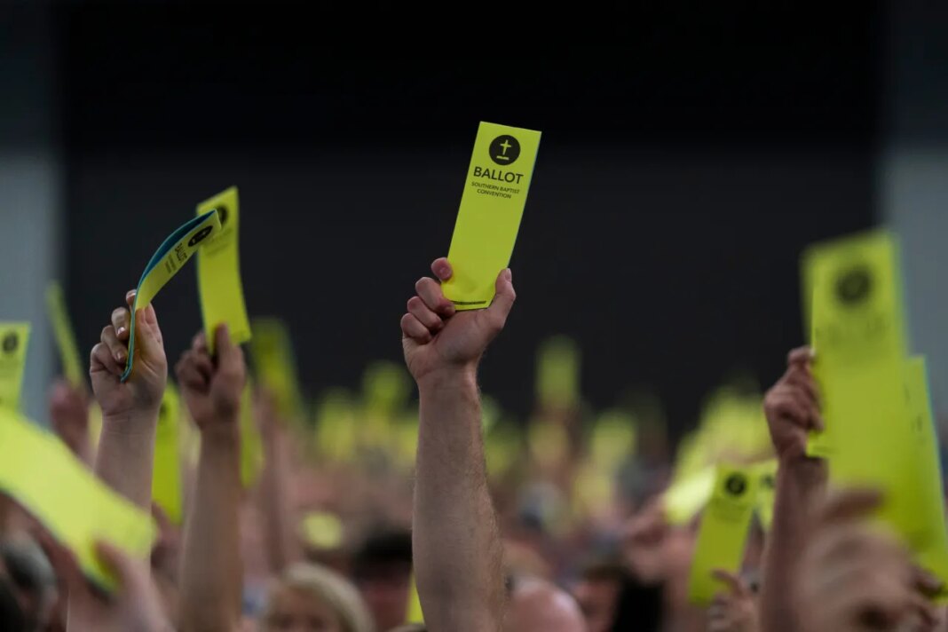 File - Attendees hold up their ballots during the Southern Baptist Convention