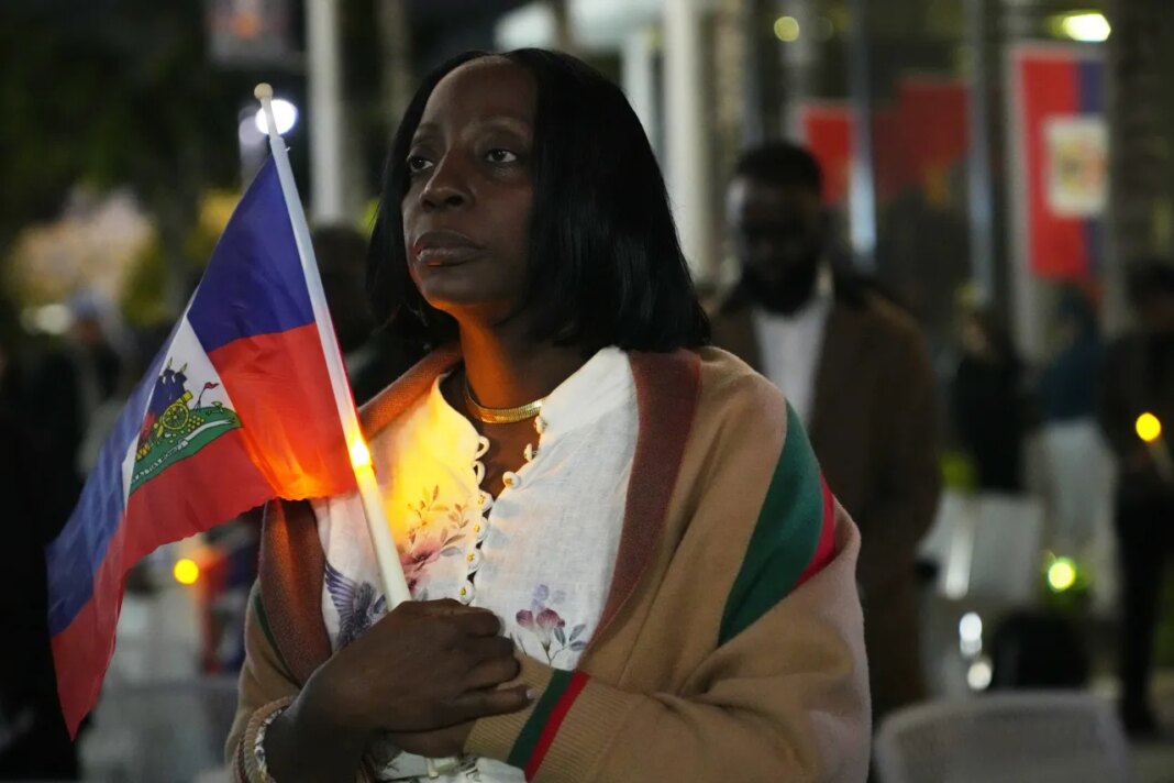 FILE - Linda Joseph holds a candle during a vigil at the Little Haiti Cultural Complex after a federal judge blocked the Trump administration from ending temporary immigration status, or TPS, for Haitians, Tuesday, Feb. 3, 2026, in North Miami. (AP Photo/Lynne Sladky, File)