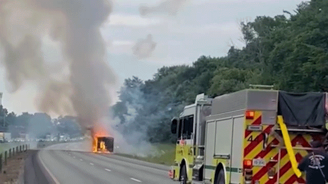 A trailer carrying fireworks burns on Interstate 75 in Tennessee as emergency crews respond and smoke billows into the sky.