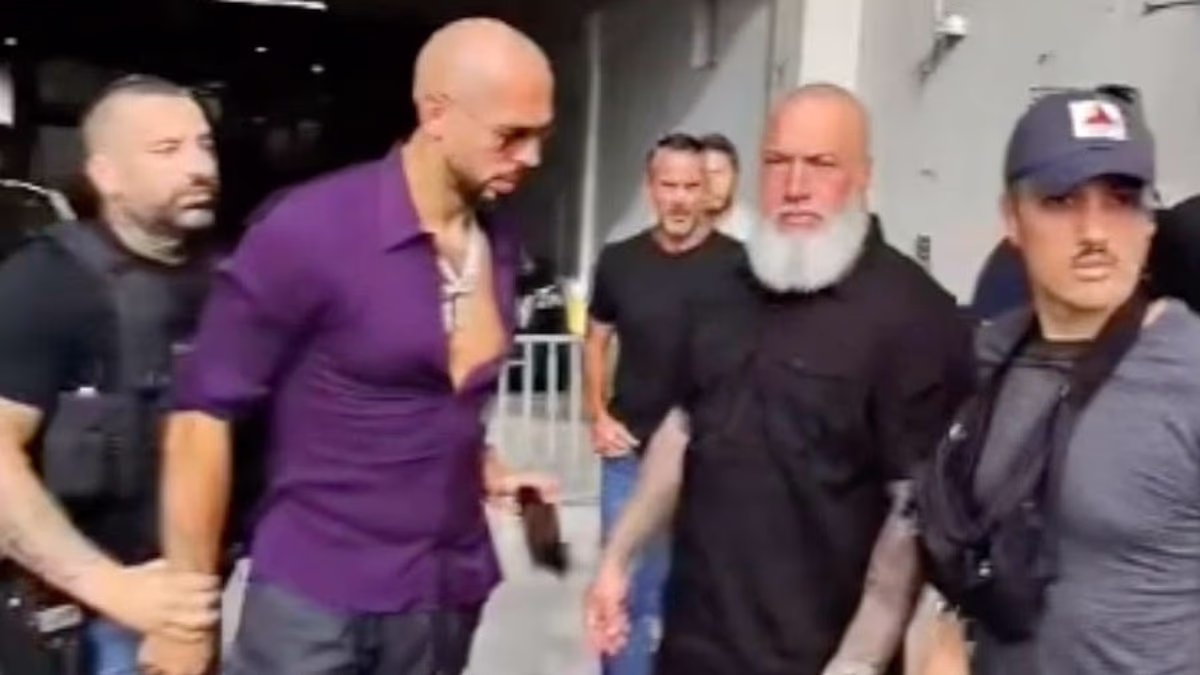 Andrew Tate appears to try and slip phone to bodyguard during arrest