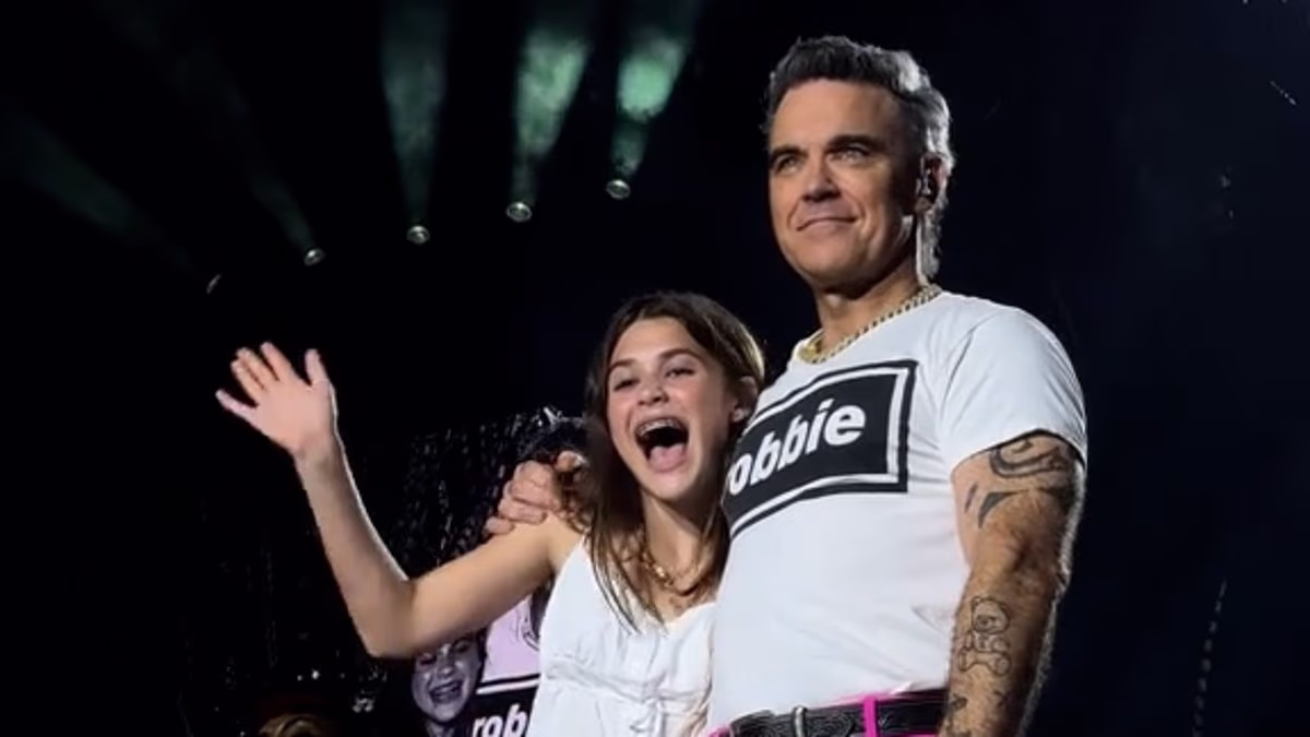 Robbie Williams brings his rarely seen daughter Teddy, 13, on stage in Luxembourg during his Britpop Tour - after revealing she is set to follow in his footsteps with her 'wonderful voice'